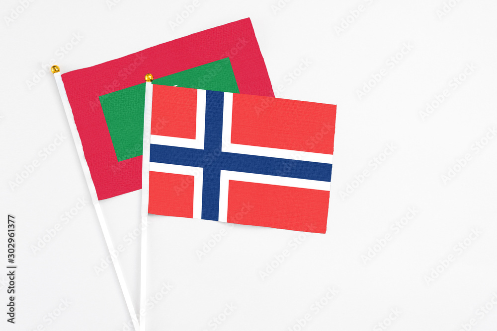 Norway and Maldives stick flags on white background. High quality fabric, miniature national flag. Peaceful global concept.White floor for copy space.