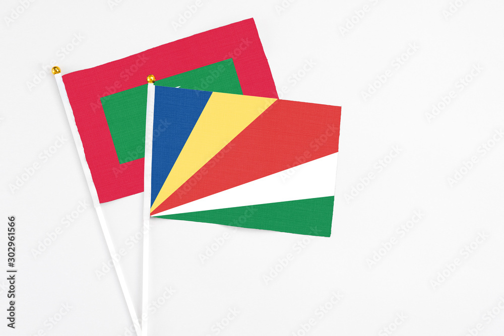 Seychelles and Maldives stick flags on white background. High quality fabric, miniature national flag. Peaceful global concept.White floor for copy space. Seychelles and Maldives stick flags on white background. High quality fabric, miniature national flag. Peaceful global concept.White floor for copy space.