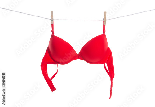 Red bra on clothespins rope on white background isolation photo