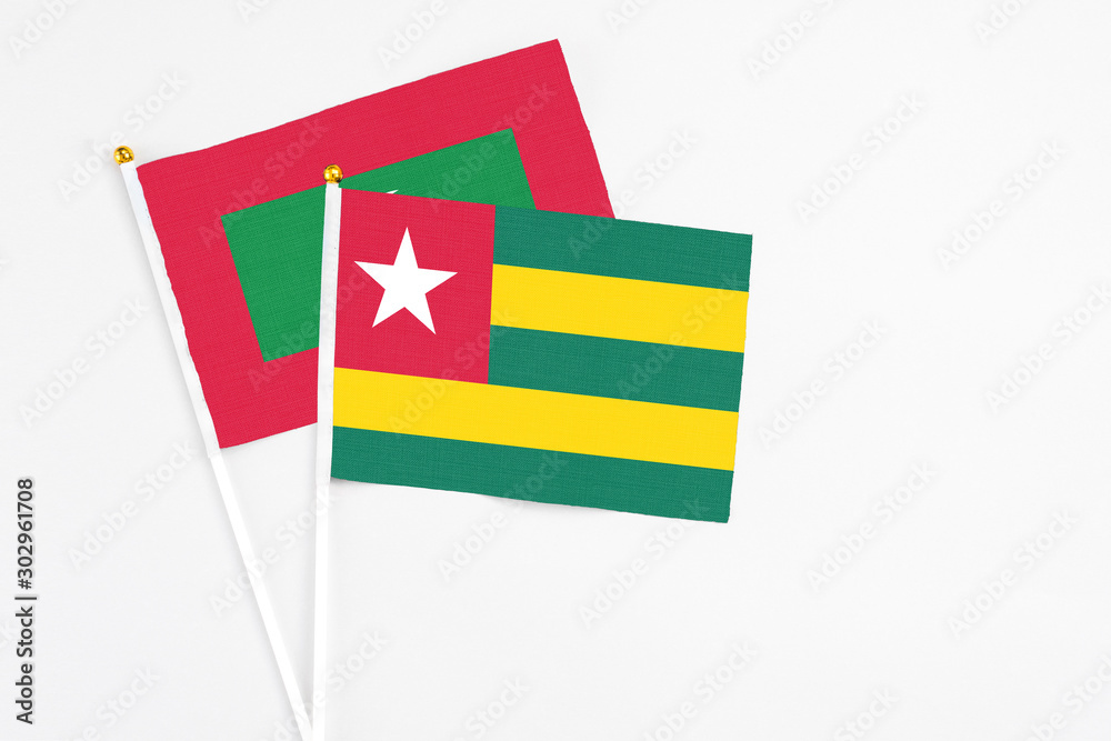 Togo and Maldives stick flags on white background. High quality fabric, miniature national flag. Peaceful global concept.White floor for copy space. Togo and Maldives stick flags on white background. High quality fabric, miniature national flag. Peaceful global concept.White floor for copy space.