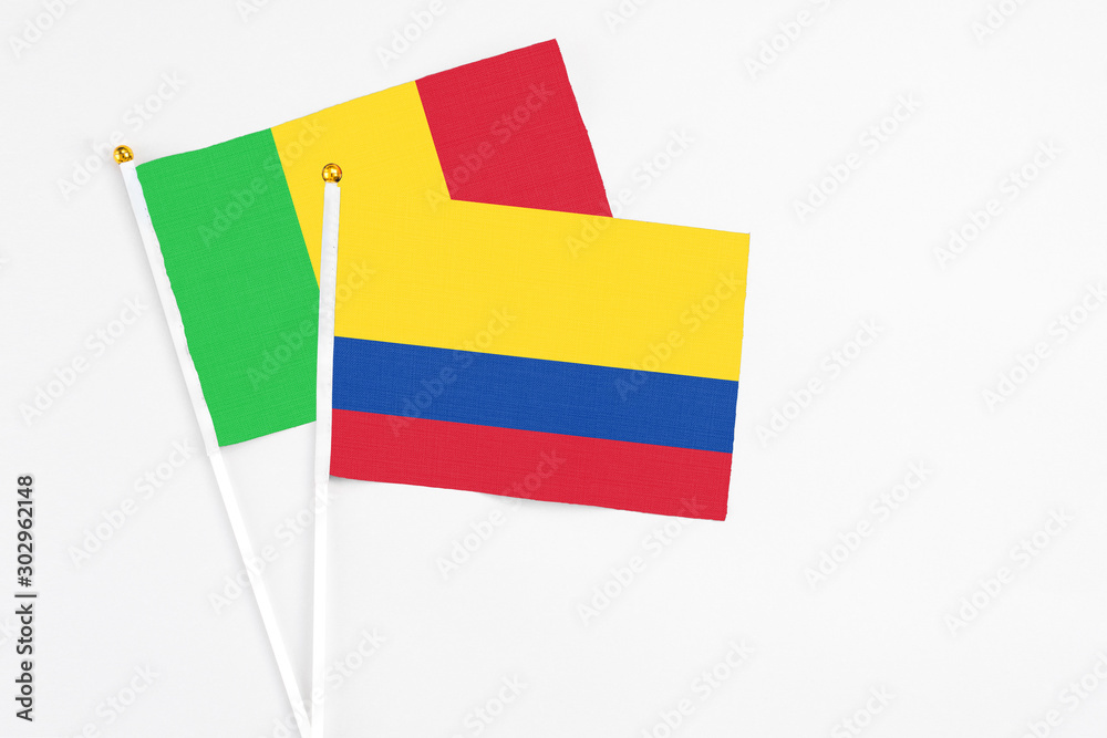 Colombia and Mali stick flags on white background. High quality fabric, miniature national flag. Peaceful global concept.White floor for copy space. Colombia and Mali stick flags on white background. High quality fabric, miniature national flag. Peaceful global concept.White floor for copy space.