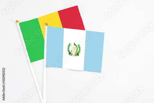 Guatemala and Mali stick flags on white background. High quality fabric, miniature national flag. Peaceful global concept.White floor for copy space.