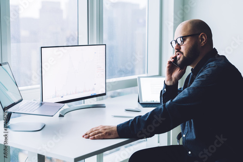 Man speaking on phone working at desk