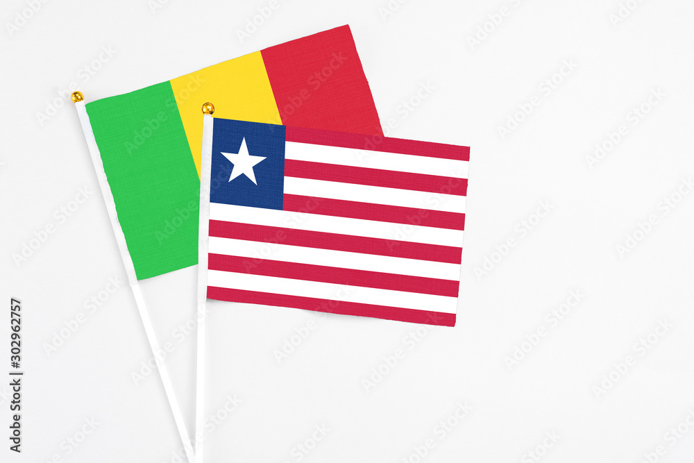 Liberia and Mali stick flags on white background. High quality fabric, miniature national flag. Peaceful global concept.White floor for copy space. Liberia and Mali stick flags on white background. High quality fabric, miniature national flag. Peaceful global concept.White floor for copy space.