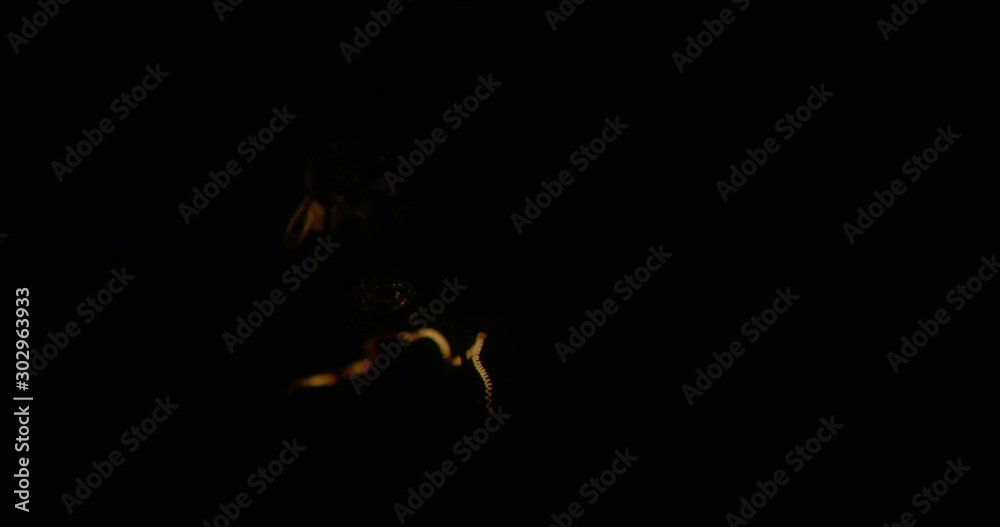 The incandescent lamp with a tungsten filament wobbles on the wire. The light flashes . Light from a light bulb. Bulb close-up. The incandescent lamp with a tungsten filament wobbles on the wire. The light flashes . Light from a light bulb. Bulb close-up.