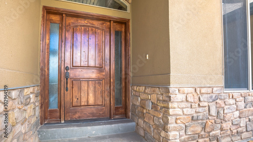 Panorama frame Brown wooden front door of home with sidelights and arched transom window