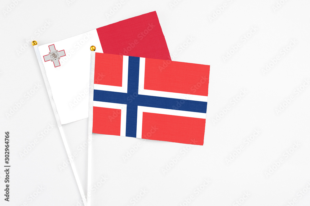 Norway and Malta stick flags on white background. High quality fabric, miniature national flag. Peaceful global concept.White floor for copy space.