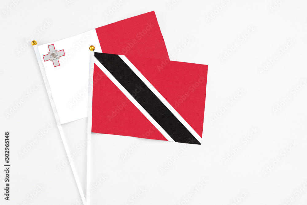 Trinidad And Tobago and Malta stick flags on white background. High quality fabric, miniature national flag. Peaceful global concept.White floor for copy space. Trinidad And Tobago and Malta stick flags on white background. High quality fabric, miniature national flag. Peaceful global concept.White floor for copy space.