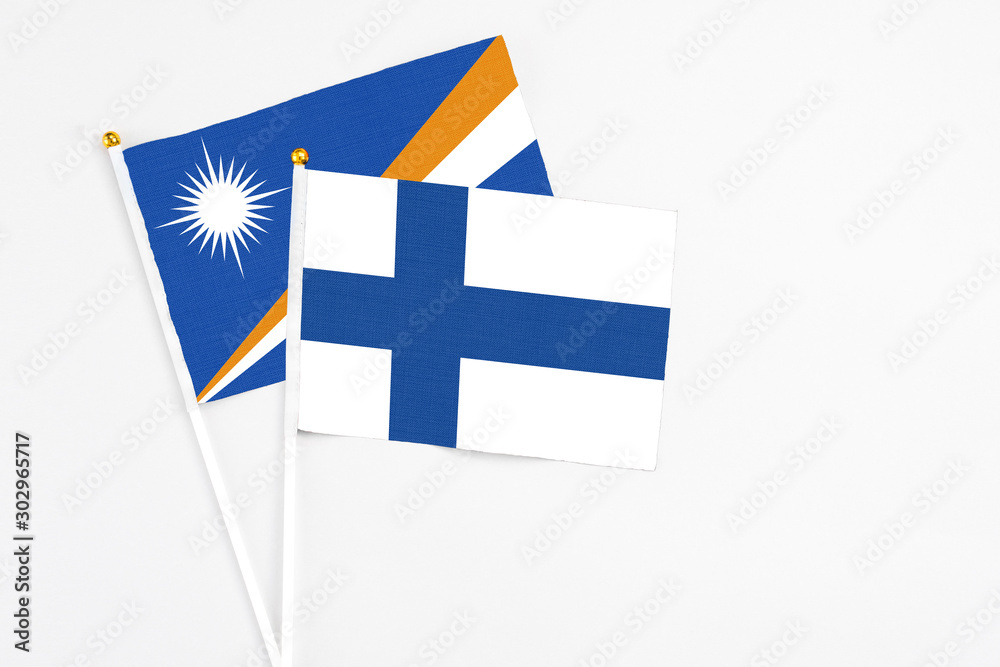 Finland and Marshall Islands stick flags on white background. High quality fabric, miniature national flag. Peaceful global concept.White floor for copy space.