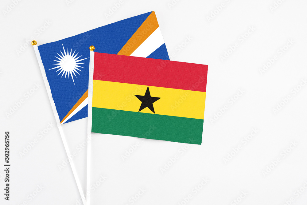 Ghana and Marshall Islands stick flags on white background. High quality fabric, miniature national flag. Peaceful global concept.White floor for copy space. Ghana and Marshall Islands stick flags on white background. High quality fabric, miniature national flag. Peaceful global concept.White floor for copy space.
