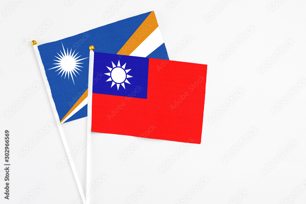 Taiwan and Marshall Islands stick flags on white background. High quality fabric, miniature national flag. Peaceful global concept.White floor for copy space. Taiwan and Marshall Islands stick flags on white background. High quality fabric, miniature national flag. Peaceful global concept.White floor for copy space.