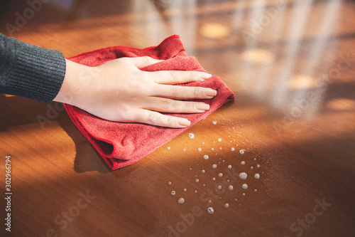 woman cleaning wooden table