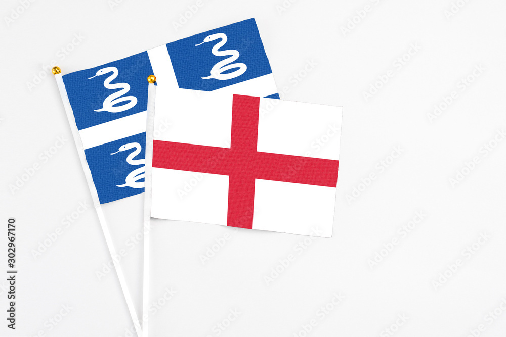 England and Martinique stick flags on white background. High quality fabric, miniature national flag. Peaceful global concept.White floor for copy space.