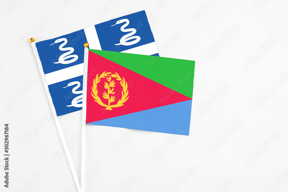 Eritrea and Martinique stick flags on white background. High quality fabric, miniature national flag. Peaceful global concept.White floor for copy space. Eritrea and Martinique stick flags on white background. High quality fabric, miniature national flag. Peaceful global concept.White floor for copy space.