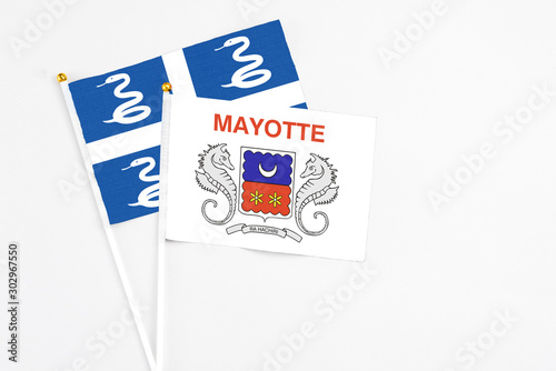 Mayotte and Martinique stick flags on white background. High quality fabric, miniature national flag. Peaceful global concept.White floor for copy space.