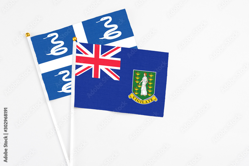 Fototapeta premium British Virgin Islands and Martinique stick flags on white background. High quality fabric, miniature national flag. Peaceful global concept.White floor for copy space.