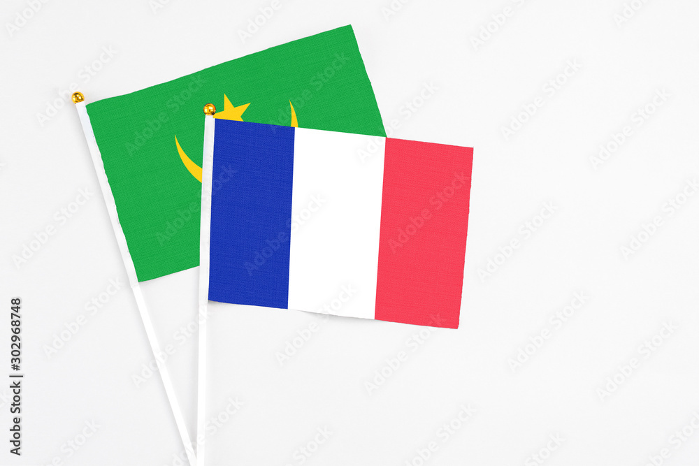 Fototapeta premium France and Mauritania stick flags on white background. High quality fabric, miniature national flag. Peaceful global concept.White floor for copy space.