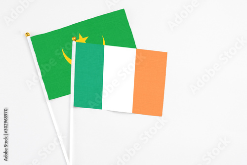 Ireland and Mauritania stick flags on white background. High quality fabric, miniature national flag. Peaceful global concept.White floor for copy space.