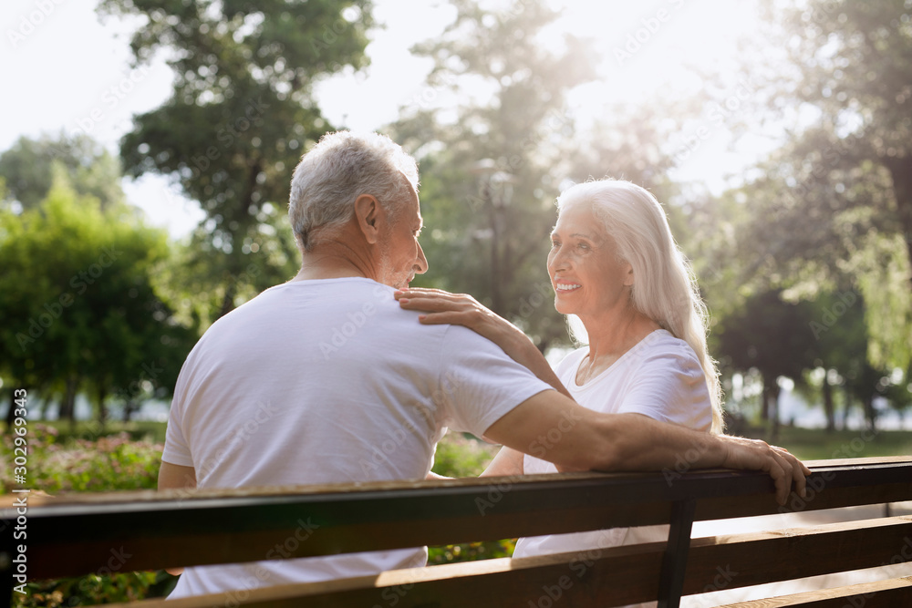 Mirthful woman smiling to her husband in the park stock photo