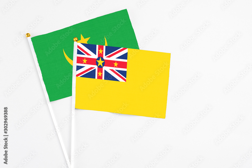 Niue and Mauritania stick flags on white background. High quality fabric, miniature national flag. Peaceful global concept.White floor for copy space. Niue and Mauritania stick flags on white background. High quality fabric, miniature national flag. Peaceful global concept.White floor for copy space.