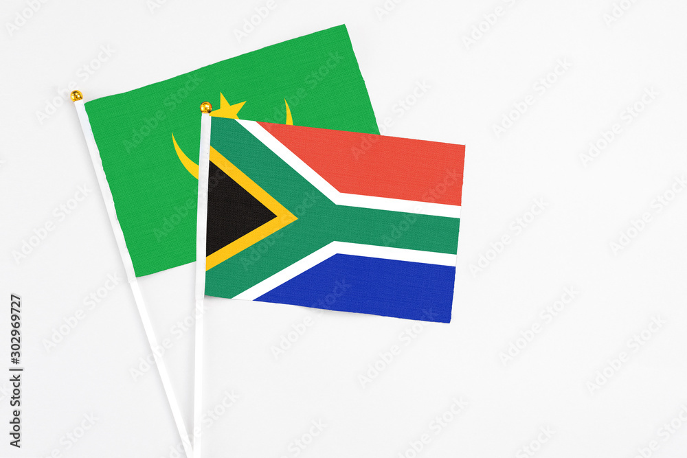 Obraz premium South Africa and Mauritania stick flags on white background. High quality fabric, miniature national flag. Peaceful global concept.White floor for copy space.