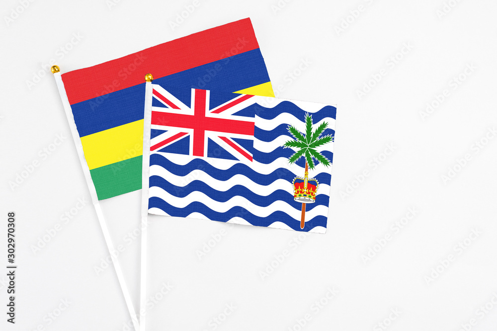 Fototapeta premium British Indian Ocean Territory and Mauritius stick flags on white background. High quality fabric, miniature national flag. Peaceful global concept.White floor for copy space.