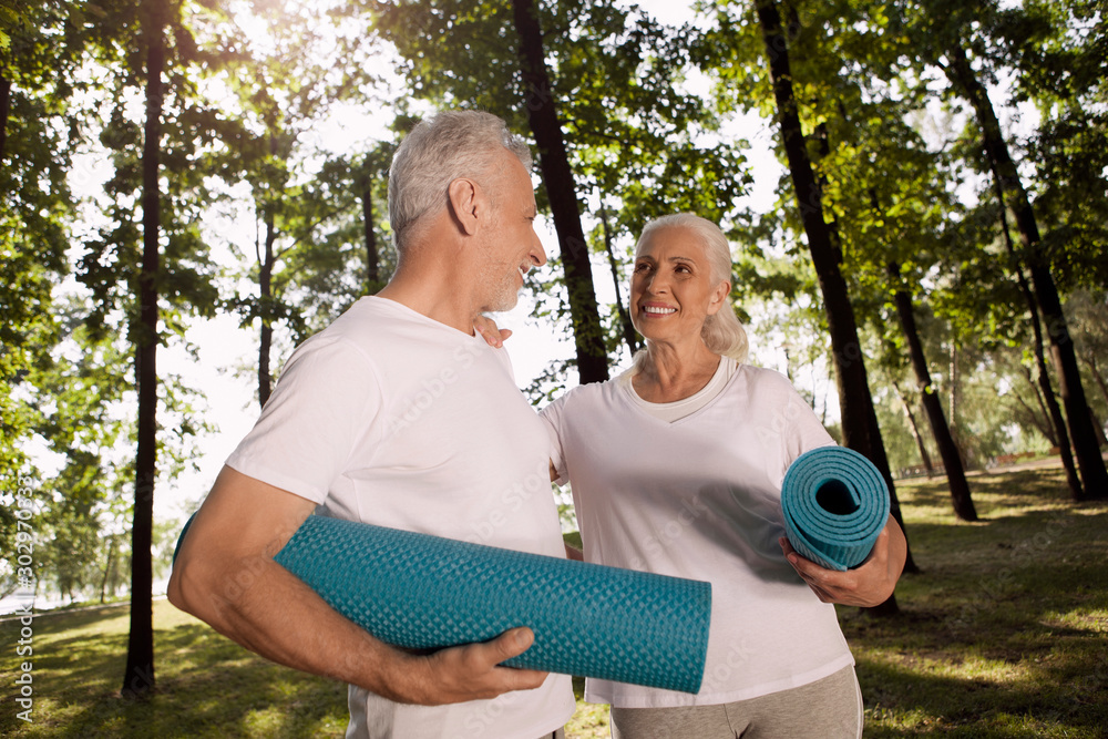 Delightful aged couple with roll mats in hands stock photo Delightful aged couple with roll mats in hands stock photo