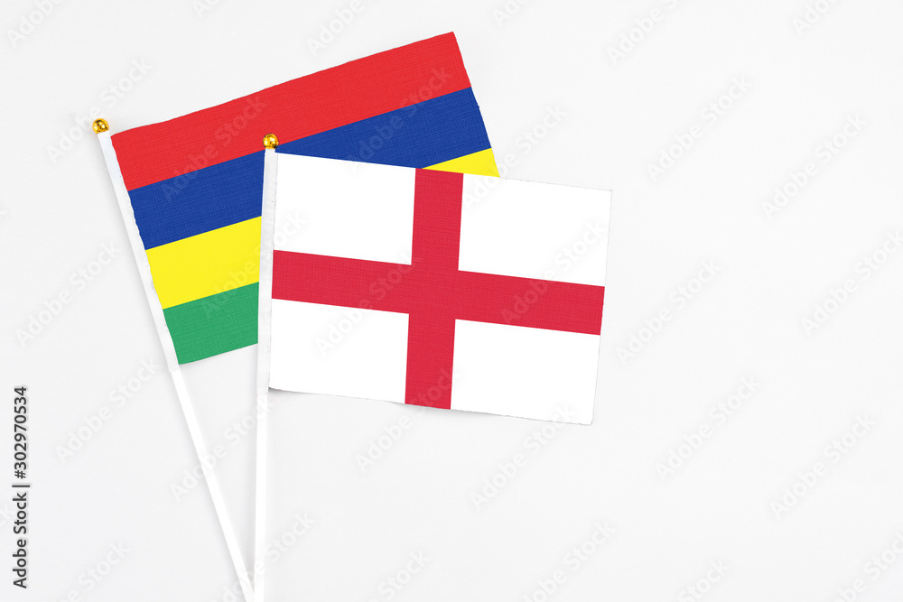 England and Mauritius stick flags on white background. High quality fabric, miniature national flag. Peaceful global concept.White floor for copy space.