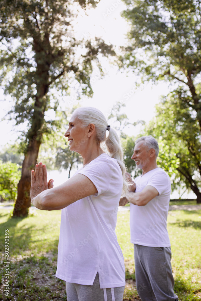 Calm pensioners meditating together stock photo