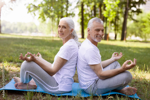 Sportive pensioners enjoying yoga outdoors stock photo