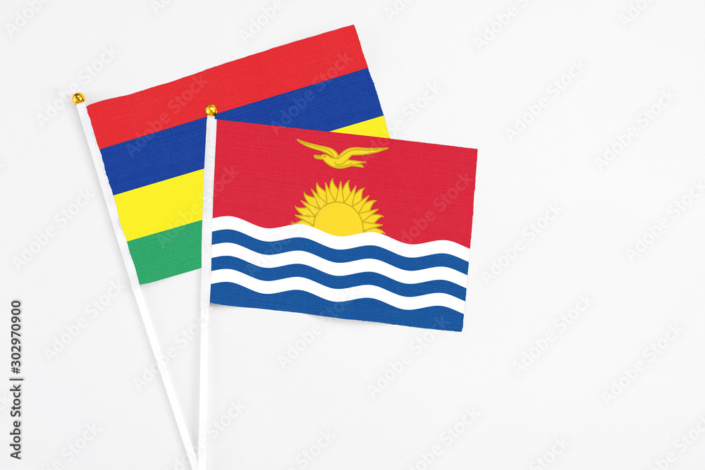 Kiribati and Mauritius stick flags on white background. High quality fabric, miniature national flag. Peaceful global concept.White floor for copy space. Kiribati and Mauritius stick flags on white background. High quality fabric, miniature national flag. Peaceful global concept.White floor for copy space.