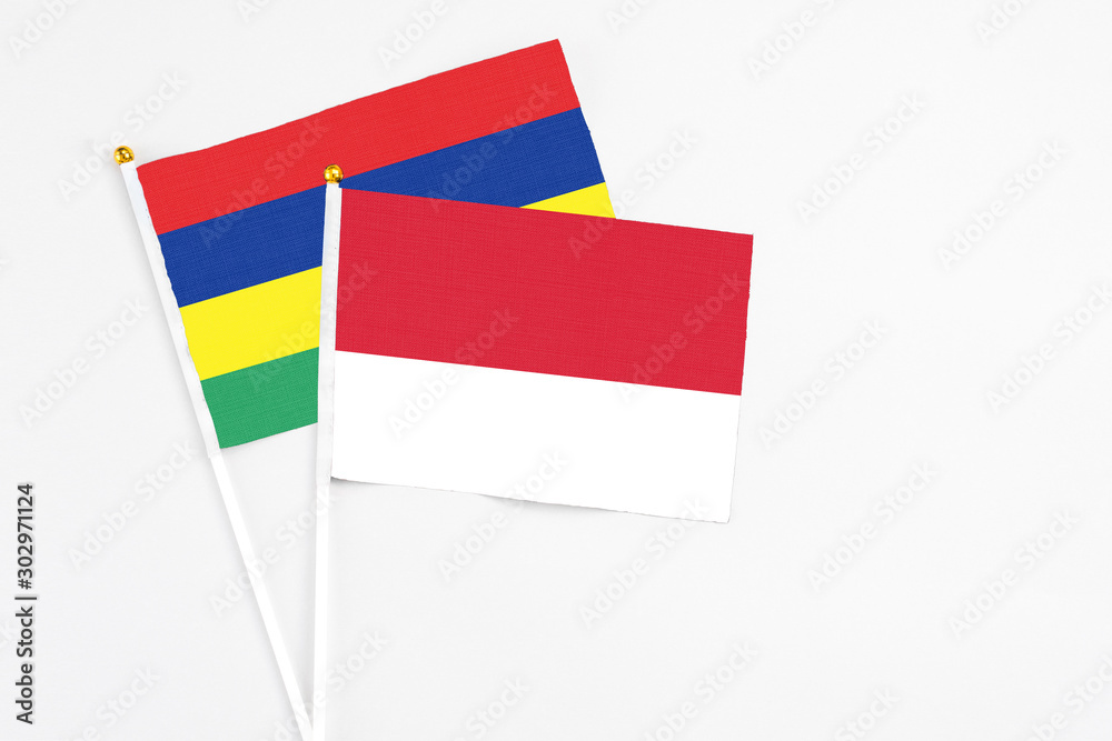 Monaco and Mauritius stick flags on white background. High quality fabric, miniature national flag. Peaceful global concept.White floor for copy space. Monaco and Mauritius stick flags on white background. High quality fabric, miniature national flag. Peaceful global concept.White floor for copy space.