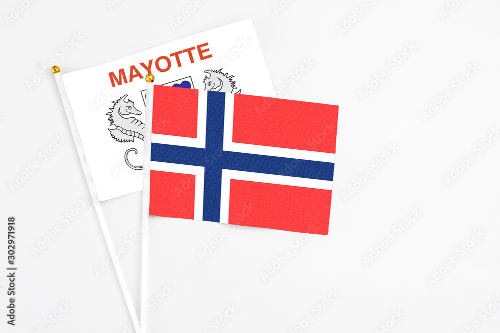 Bouvet Islands and Mayotte stick flags on white background. High quality fabric, miniature national flag. Peaceful global concept.White floor for copy space.