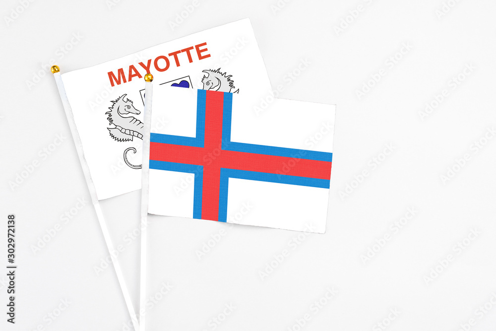 Faroe Islands and Mayotte stick flags on white background. High quality fabric, miniature national flag. Peaceful global concept.White floor for copy space. Faroe Islands and Mayotte stick flags on white background. High quality fabric, miniature national flag. Peaceful global concept.White floor for copy space.