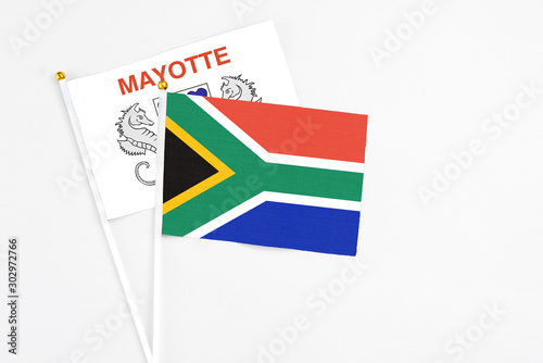 South Africa and Mayotte stick flags on white background. High quality fabric  miniature national flag. Peaceful global concept.White floor for copy space.