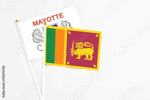 Sri Lanka and Mayotte stick flags on white background. High quality fabric, miniature national flag. Peaceful global concept.White floor for copy space.