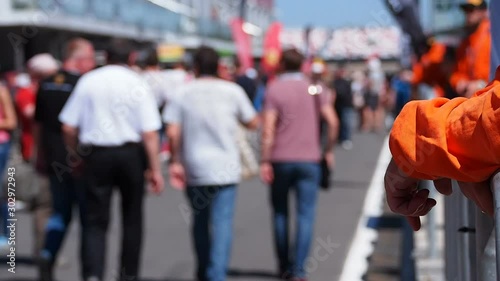 Blurred Out Crowd Walking on a Raceway Pitlane