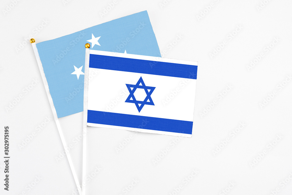 Israel and Micronesia stick flags on white background. High quality fabric, miniature national flag. Peaceful global concept.White floor for copy space.