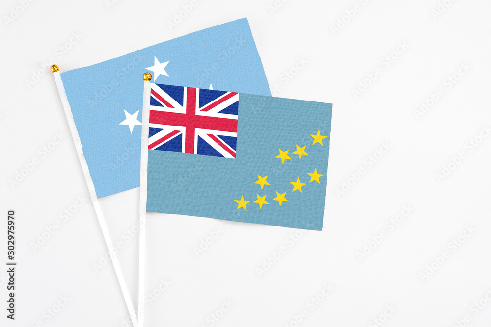 Tuvalu and Micronesia stick flags on white background. High quality fabric, miniature national flag. Peaceful global concept.White floor for copy space. Tuvalu and Micronesia stick flags on white background. High quality fabric, miniature national flag. Peaceful global concept.White floor for copy space.