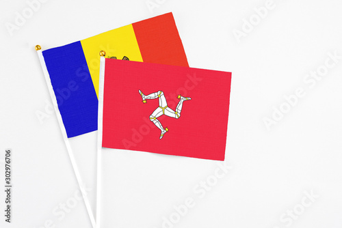 Isle Of Man and Moldova stick flags on white background. High quality fabric, miniature national flag. Peaceful global concept.White floor for copy space.
