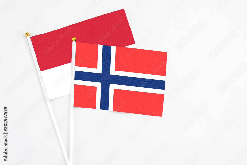Bouvet Islands and Monaco stick flags on white background. High quality fabric, miniature national flag. Peaceful global concept.White floor for copy space.
