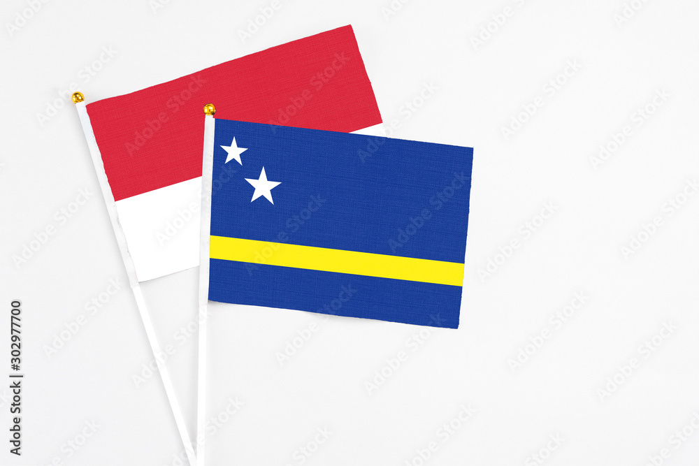 Curacao and Monaco stick flags on white background. High quality fabric, miniature national flag. Peaceful global concept.White floor for copy space. Curacao and Monaco stick flags on white background. High quality fabric, miniature national flag. Peaceful global concept.White floor for copy space.