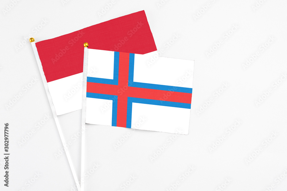 Faroe Islands and Monaco stick flags on white background. High quality fabric, miniature national flag. Peaceful global concept.White floor for copy space.