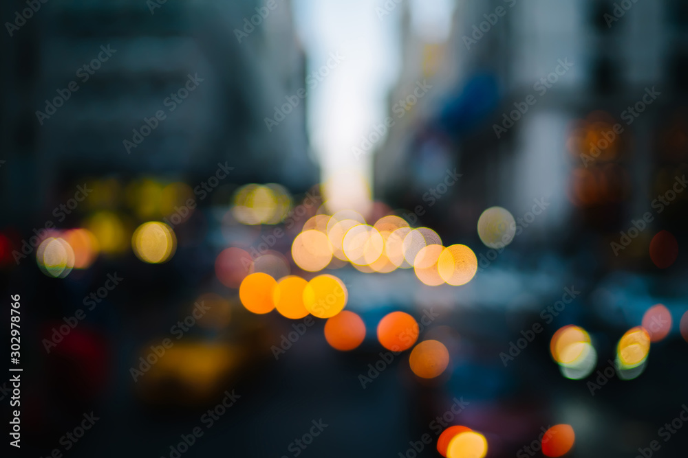 Evening defocused view with bokeh lights of urban setting and moving cars on road in city district,blurred background of transportation in Metropolis downtown with copy space for advertise information