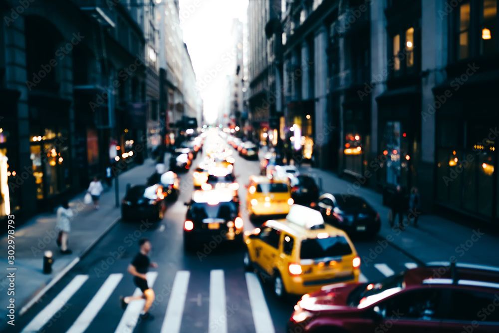 Blurred photo of big city life with traffic on road and pedestrian passing crosswalk in downtown, cityscape with modern architecture and transport moving on avenue in district of New York megalopolis