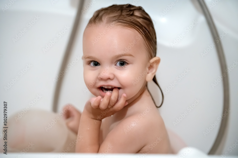 little beautiful girl with blue eyes and wet hair bathes in a bath little beautiful girl with blue eyes and wet hair bathes in a bath