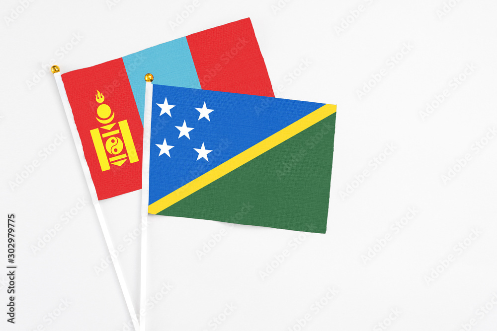 Solomon Islands and Mongolia stick flags on white background. High quality fabric, miniature national flag. Peaceful global concept.White floor for copy space. Solomon Islands and Mongolia stick flags on white background. High quality fabric, miniature national flag. Peaceful global concept.White floor for copy space.