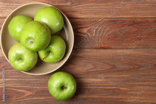 juicy green apples on a wooden table.