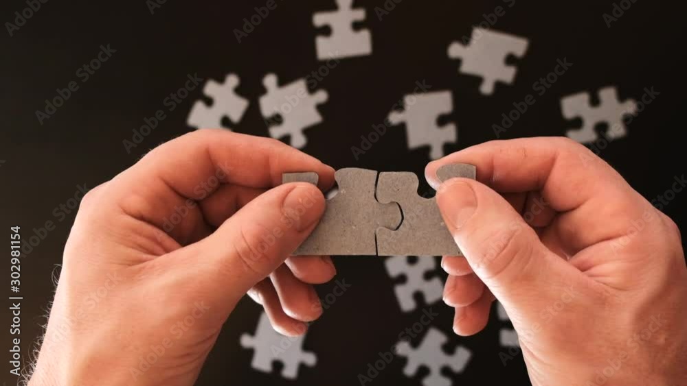 Matching puzzle.business finance concept. male hands connect two puzzles. Jigsaw puzzle.Two puzzles in male hands connect