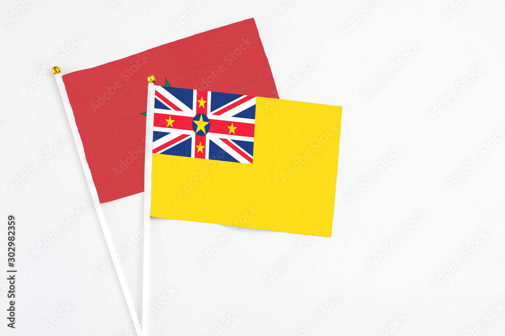 Niue and Morocco stick flags on white background. High quality fabric, miniature national flag. Peaceful global concept.White floor for copy space. Niue and Morocco stick flags on white background. High quality fabric, miniature national flag. Peaceful global concept.White floor for copy space.